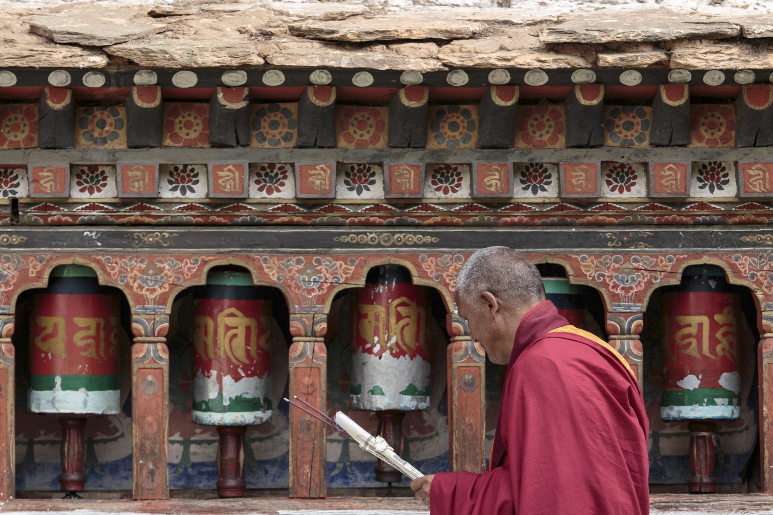 Kyichu Lhakhang is the oldest temple in Paro. Here, a monk practises his faith by turning prayer wheels set in the walls of the monastery
